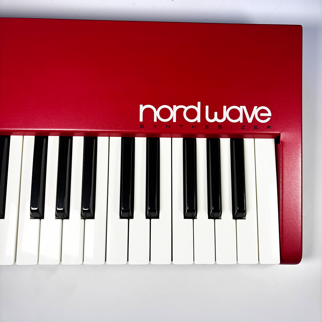 Red Nord Wave synthesizer keyboard on a white background